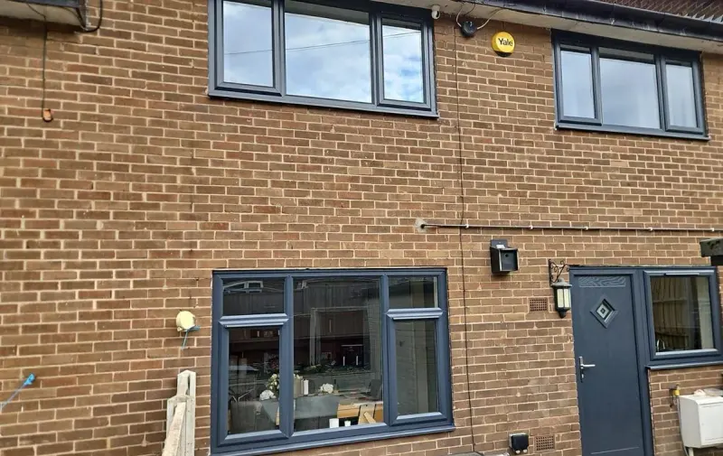 Rear elevation in red brick with three anthracite windows and an anthracite composite door with diamond glazing.